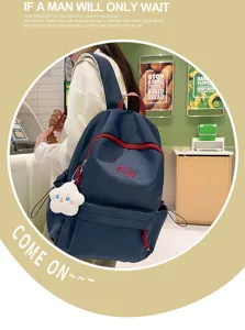 Elegante mochila escolar azul oscura para mujer con cremalleras rojas y lindo colgante de nube.