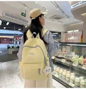 Mochila de lona amarilla vista detalle lifestyle, bolso casual con bonito colgante.