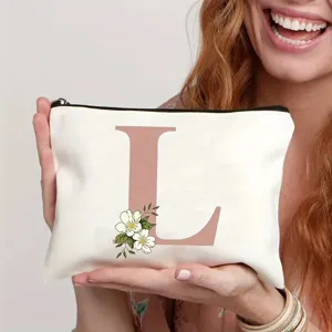 Trousse de maquillage en toile avec lettre L et motif floral, pochette de voyage idéale.