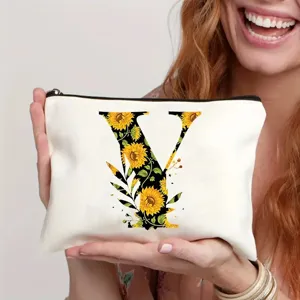 Close-up detail of white cosmetic bag featuring sunflower letter print and zipper closure.