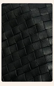 Vue détaillée de la texture tissée à la main en cuir véritable, matériau noir souple et de qualité.