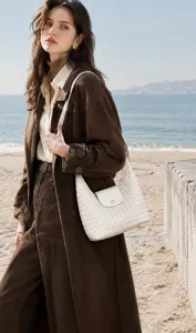 Vue détaillée du sac porté épaule en cuir tissé blanc mettant en valeur l'artisanat.