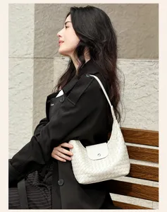 Detail de sac a epaule en cuir tresse blanc, elegante sacoche pour femme au design raffine.