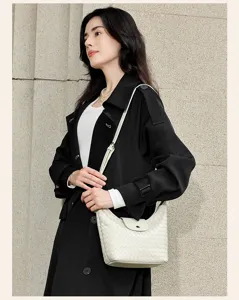 Vue détaillée de l'élégant sac à bandoulière en cuir tissé porté par le mannequin.