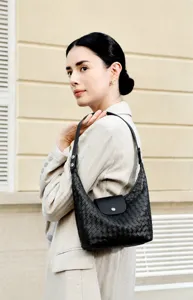 Sac a main hobo en cuir tisse noir avec rabat elegant et finition texturee de qualite.