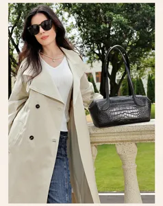 Detailed view of black crocodile embossed leather Boston shoulder bag with dual top handles.