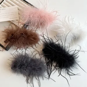 Nahaufnahme flauschiger Feder-Haarspangen in verschiedenen schicken Farben für Herbst und Winter.
