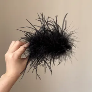 Schwarze flauschige Feder Haarspange Nahaufnahme, weiche Textur Detail für elegante Herbst Mode.
