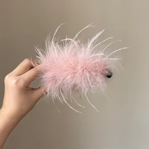 Nahaufnahme einer flauschigen rosa Feder Haarspange Detail, weiche Textur für elegante Frisuren.