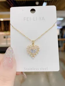 Exquisite heart pendant necklace detail showing sparkling rhinestones and delicate pearls design.