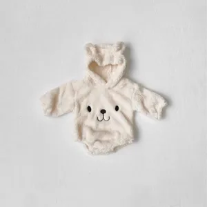 Close-up of fluffy baby bear romper detail, soft cream fleece fabric with cute ears.