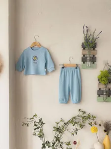 Conjunto casual de otoño para niña con camiseta de manga larga acanalada y pantalón azul.