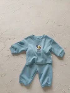 Vista detallada del conjunto de sudadera acanalada azul claro para bebé con bordado de margarita.