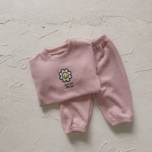 Detalles cercanos del conjunto informal de canalé rosa para niñas con bordado de margarita.