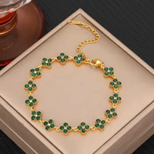 Close-up of green zircon four leaf clover bracelet detail, luxury gold steel jewelry accessory.