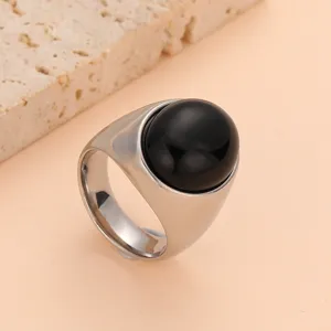Détail de bague en acier inoxydable avec pierre cabochon noire polie au design large et élégant.
