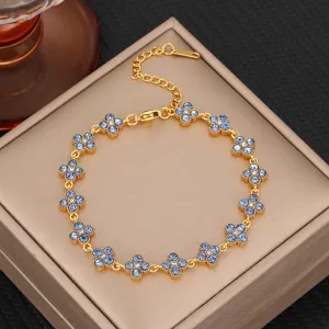 Close-up detail of the luxury blue zirconia four leaf clover gold bracelet design.