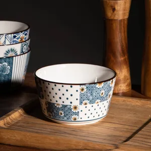 Close-up detail of Japanese style ceramic rice bowl with underglaze floral and dot pattern.