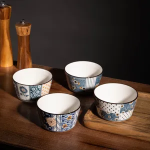 Detailed view of Japanese style ceramic bowls with blue floral patterns on wooden tabletop.