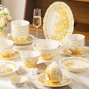 Service de vaisselle en céramique florale émaillée jaune, beaux bols et assiettes pour repas.