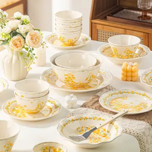 Service de vaisselle en céramique avec motif floral jaune, bols et assiettes pour la cuisine.