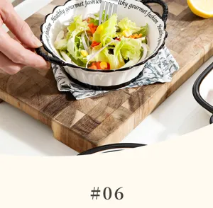 Gedetailleerde opname van keramische schaal met salade, zwarte rand en stijlvol design.