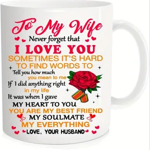 Vista detallada de taza de café de cerámica blanca con cita romántica y rosa roja.
