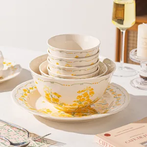 Set de vaisselle en ceramique elegante avec motif floral jaune, bols a riz et grandes assiettes.