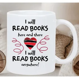 Detailed shot of white ceramic coffee mug with book lover typography and red heart print.