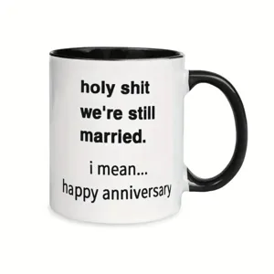Close-up of ceramic coffee mug, black handle and rim with funny anniversary text print.