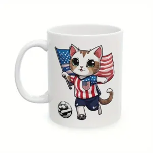 White ceramic coffee mug with cute cartoon cat playing soccer and patriotic design, 11oz.
