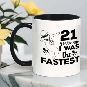 Taza de café de cerámica blanca con asa negra y estampado divertido para uso en oficina.