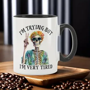 Ceramic coffee mug detail shot, skeleton illustration graphic, office drinkware close-up.
