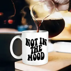 Detailansicht der weißen Keramiktasse mit schwarzem Text, schöne Kaffeegießen Szene.