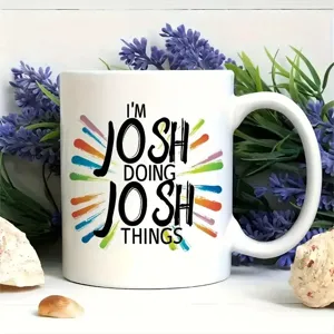 Ceramic coffee mug detail, white cup with colorful splash print and custom text design.