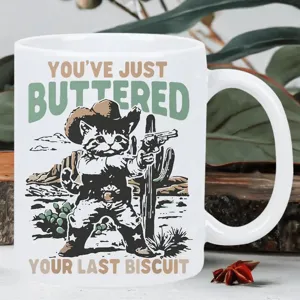 Close-up of a funny cowboy cat ceramic mug, cute western graphic detail for coffee lovers.