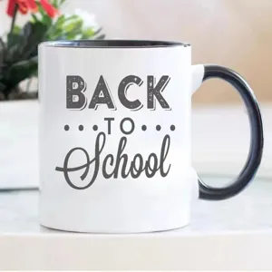 Taza de café de cerámica blanca con asa negra, estampado escolar, detalle de oficina moderna.
