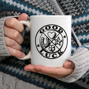 Gros plan sur une tasse à café en céramique blanche avec un motif porte-bonheur noir.