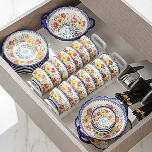 Bohemian ceramic tableware set featuring floral bowls, plates, and chopsticks organized in drawer.