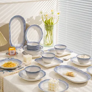 Service de vaisselle en céramique bleu fumée français, bols et assiettes élégants pour table.