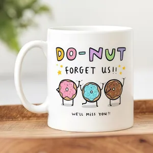 Primer plano de una taza de café de cerámica blanca con bonitos gráficos de donuts y citas graciosas.