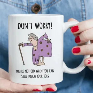 Funny ceramic coffee mug with humorous elderly cartoon print and quote text for office use.
