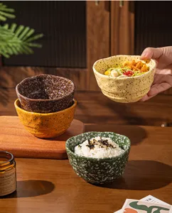 Vue détaillée de bol en céramique irrégulier avec design moucheté pour riz, salades, desserts.