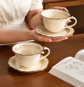 Primer plano del juego de taza y platillo de café de cerámica vintage con textura artesanal.