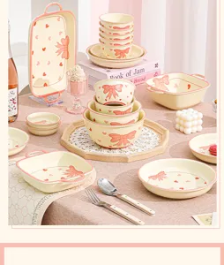 Dettaglio servizio di piatti in ceramica stile INS con grazioso fiocco rosa e cuore.