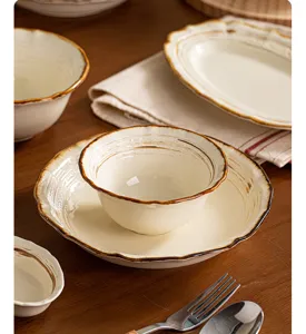 Vue de détail rapprochée d'assiettes et bols en céramique rétro avec bord décoratif.