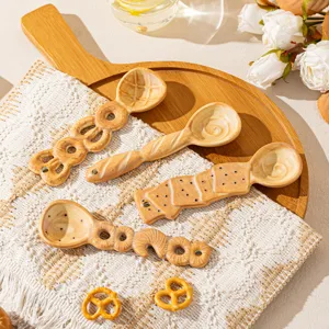 Bonito juego de cucharas de cerámica, forma de galleta y pan de panadería para postre.