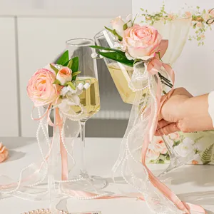 Hochzeit Sektgläser dekoriert mit rosa Rosen und weißen Bändern für Brautpaar Feier.