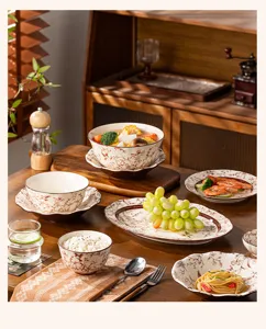 Detailed shot of elegant retro ceramic tableware set with floral pattern on wooden table.