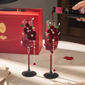 Elegant wedding champagne glasses set with red velvet flowers and pearls for bridal toast gift.